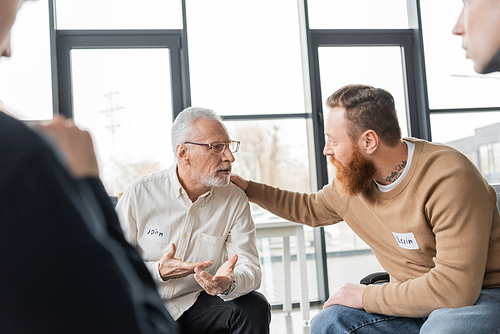 Middle aged man with alcohol addiction sharing problem with group in rehab center