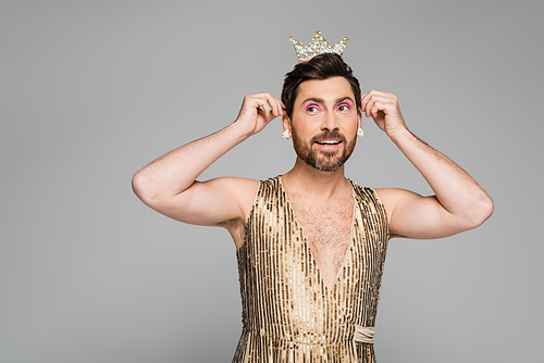 cheerful man wearing toy crown on head while standing in princess dress costume isolated on grey