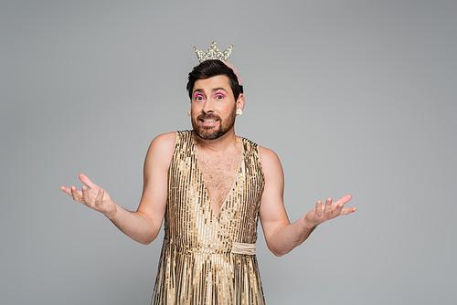 bearded man with toy crown on head and princess dress costume showing shrug gesture isolated on grey