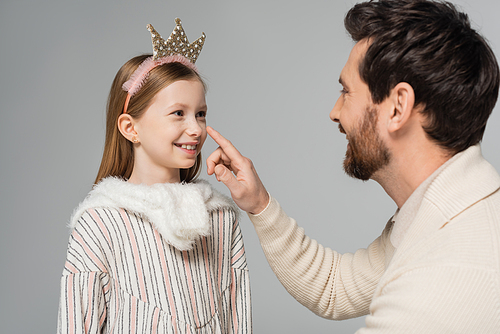 happy bearded man touching nose of cute daughter in crown isolated on grey