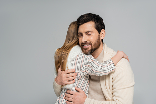 daughter hugging happy father with closed eyes isolated on grey