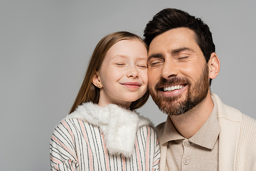 portrait of cheerful father and daughter smiling with closed eyes isolated on grey