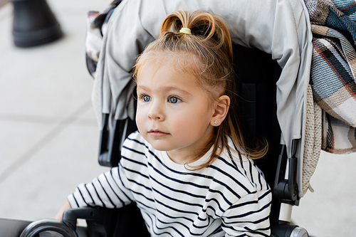 toddler girl in striped long sleeve shirt sitting in baby stroller