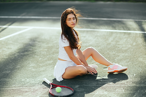woman resting after game, female tennis player with long hair sitting in white outfit near racket with ball on asphalt, blurred background, Miami, tennis court, downtime, shadows, sunny day