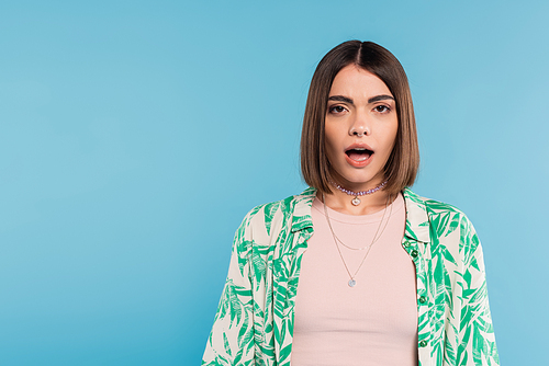 emotional woman with opened mouth, shocked model looking at camera on blue background, shirt with palm tree print, nose piercing, casual attire, generation z, surprised face
