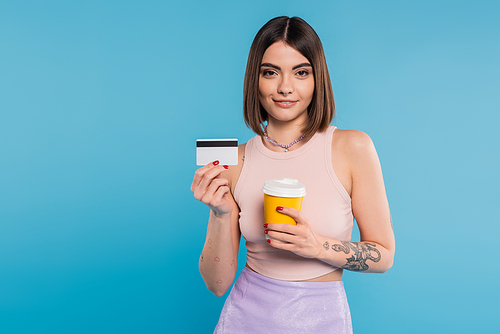 to go coffee, happy young woman with short hair, tattoos and nose piercing holding paper cup and credit card on blue background, generation z, summer trends, attractive, coffee culture