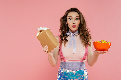 housewife concept, shocked young woman posing like a doll, holding takeaway food and bowl with corn flakes, pink background, conceptual photography, home duties, emotional