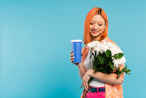 spring vibes, joyful asian and young woman with red hair holding paper cup and bouquet of flowers on blue background, casual attire, generation z, coffee culture, hot beverage, coffee to go
