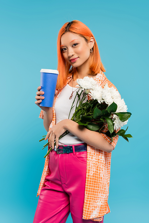 spring vibes, asian and young woman with dyed red hair holding paper cup and bouquet of flowers on blue background, casual attire, generation z, takeaway culture, hot beverage, coffee to go