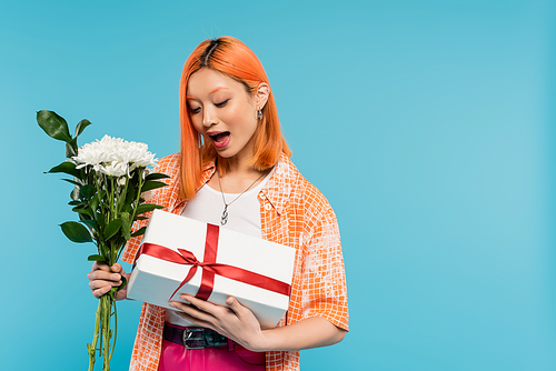 floral bouquet, holiday, present, surprised and young asian woman with dyed hair holding white flowers and gift box on blue background, casual attire, generation z, festive celebration, birthday