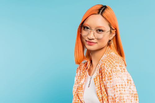 youthfulness and happiness, pretty asian woman with colored red hair, in fashionable eyeglasses and orange shirt smiling at camera on blue background, generation z, summer vibes