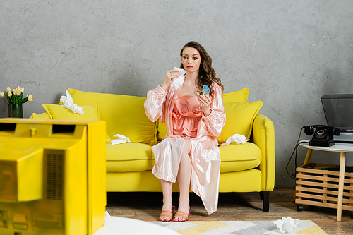 emotional stress, sad woman with smudged mascara sitting on yellow couch, housewife with crying eyes holding napkin and cocktail, watching tv, depressed and heartbroken wife at home