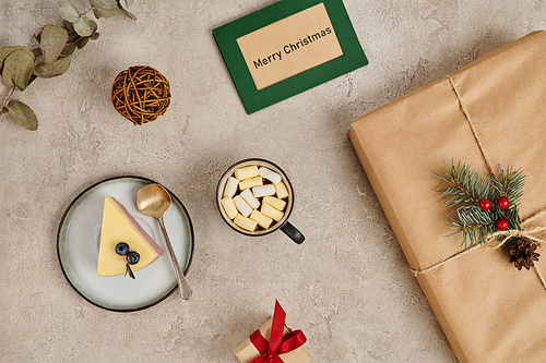 traditional Christmas treats, pudding and hot chocolate with marshmallows near decorated gift box