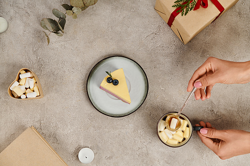 partial view of woman with tea spoon near hot chocolate with marshmallows and Christmas pudding