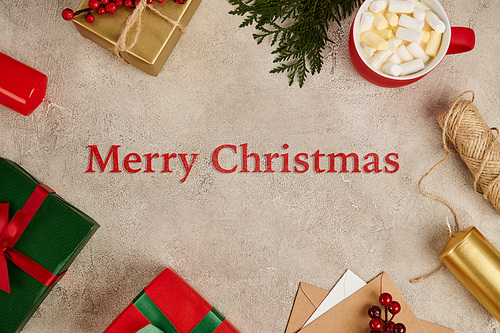 Merry Christmas greeting in frame with colorful present boxes and hot chocolate with marshmallow