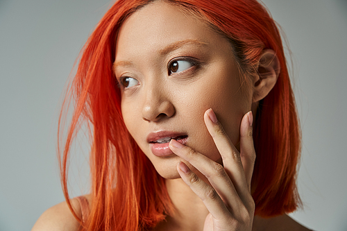 asian beauty, young woman with red hair and natural makeup looking away and touching cheek