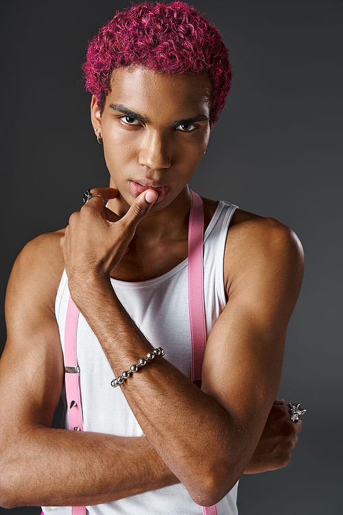 handsome african american man with pink hair alluringly looking at camera, fashion and style