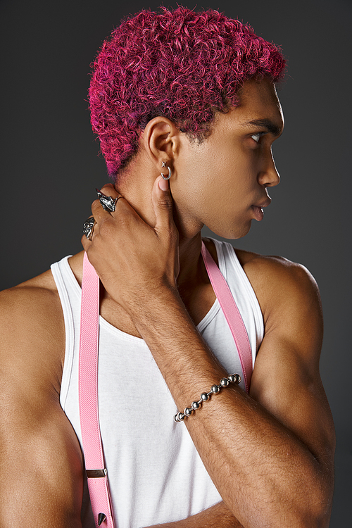 portrait of young african american man with silver accessories and pink hair, fashion and style