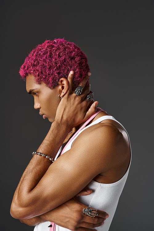 handsome man with pink hair posing with crossed arms and one hand behind neck, fashion and style