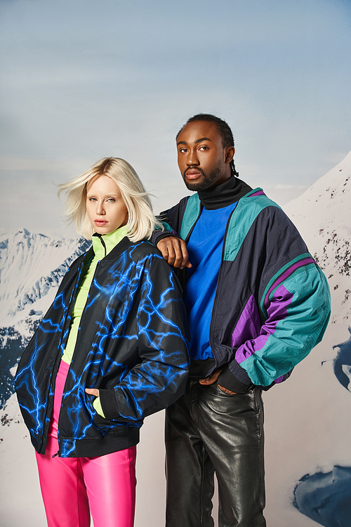 attractive young interracial couple in warm stylish attire looking at camera, winter concept