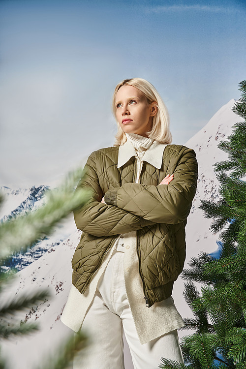 serious stylish woman posing with her arms crossed on chest and looking away, winter fashion