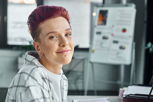 professional headshot of positive bigender entrepreneur looking at camera in modern office