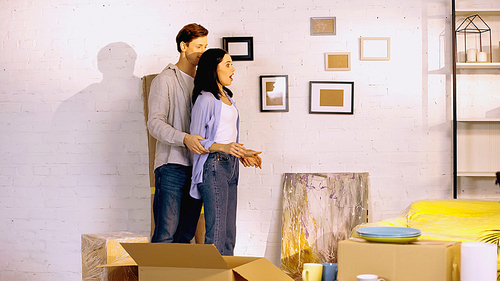 shocked woman looking at new home near boyfriend