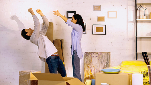 excited couple rejoicing in new home