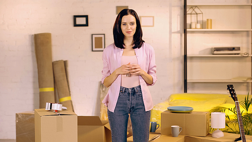 cheerful woman looking at camera in new home