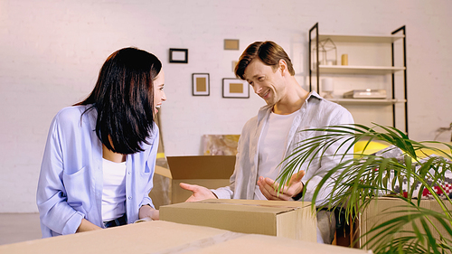 happy couple looking at each other while packing box