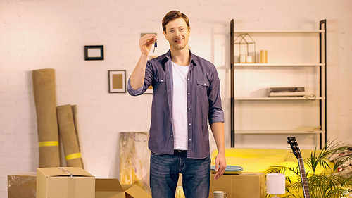 happy man standing with keys in new home