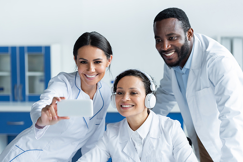 Cheerful multiethnic doctors using blurred smartphone in clinic