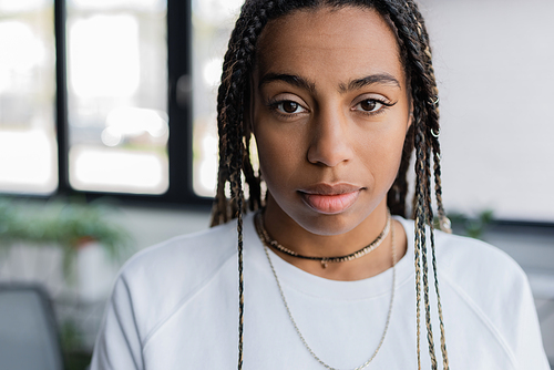 Portrait of african american woman in t-shirt looking at camera in office