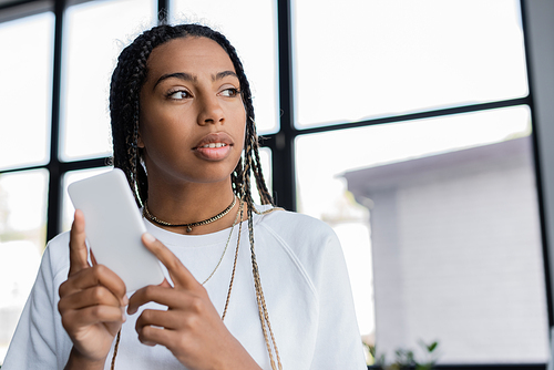 African american businessman holding cellphone in office