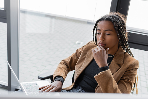 Focused african american businesswoman using laptop in office