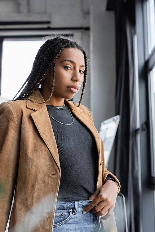 African american businesswoman in jacket looking at camera in office