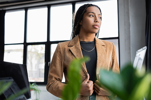 African american businesswoman in jacket looking away in office