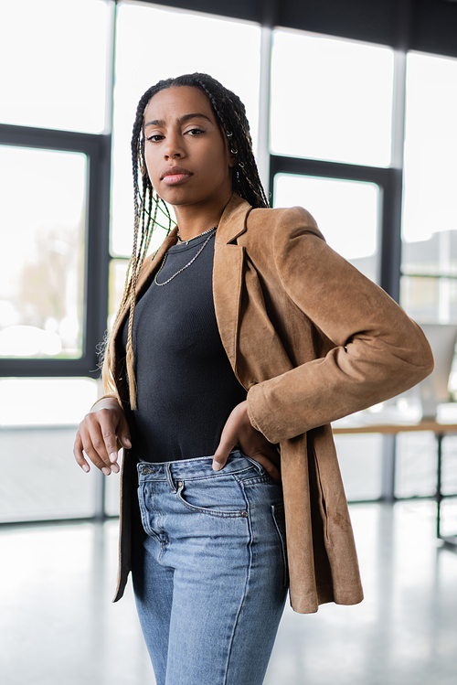 African american businesswoman in jacket and jeans standing in office