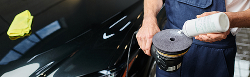 cropped view of devoted professional worker in uniform applying polishing paste on machine, banner