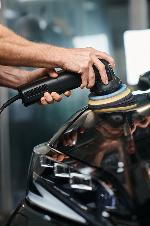 cropped view of dedicated professional serviceman using polishing machine on black modern car