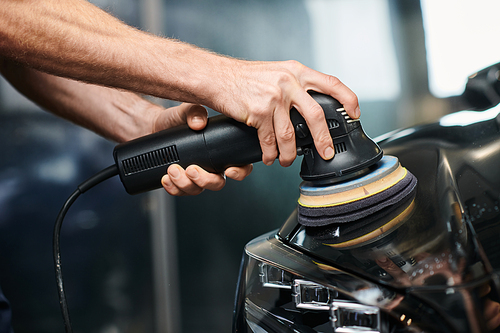 cropped view of dedicated professional using polishing machine carefully on black modern car