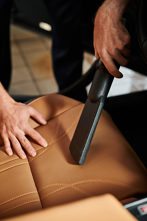 cropped view of hard working professional serviceman using carefully manual vacuum cleaner