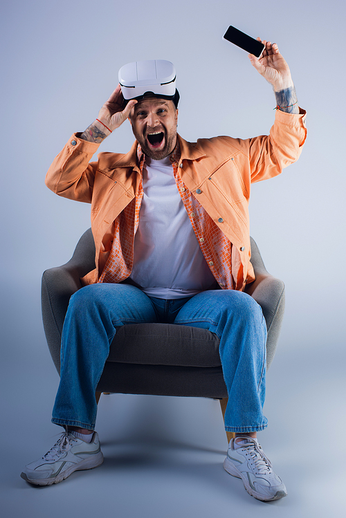 A man sits comfortably in a chair wearing a vr headset, lost in thought.