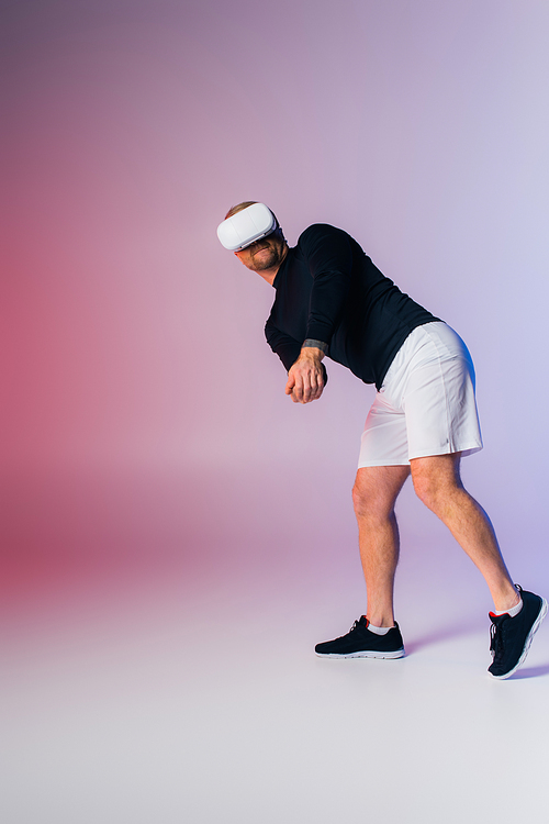 A man in a black shirt and white shorts is energetically playing tennis on a court.