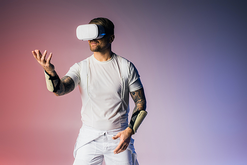 A man in a virtual reality headset poses in a studio wearing a white shirt and white shorts.