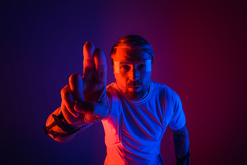 A man in a white shirt makes a hand gesture in a studio setting, wearing smart glasses for the metaverse experience.