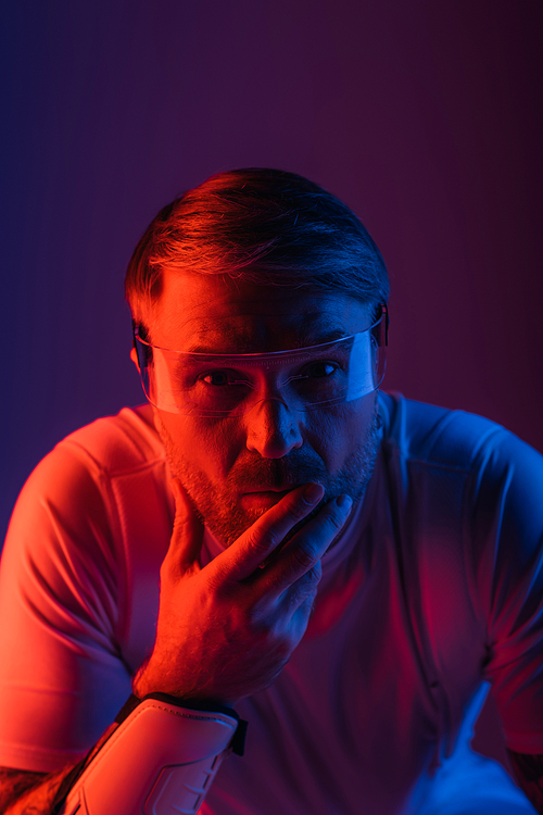 A man in smart glasses, dressed in a white shirt, gazes directly at the camera in a studio set for a metaverse experience.