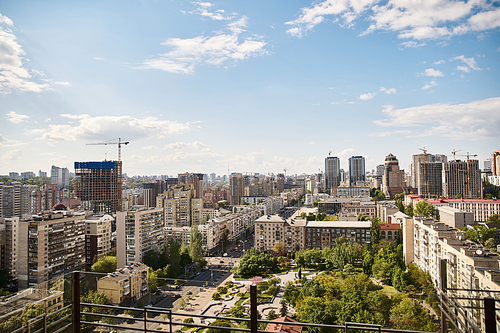 A picturesque city sprawls beneath, viewed from a tall building, showcasing skyscrapers, bustling streets, and vibrant city life