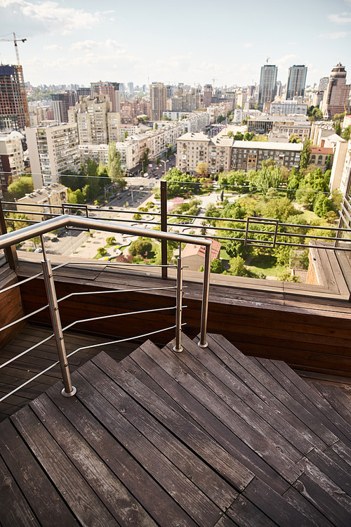 A breathtaking panorama of a bustling cityscape from atop a high-rise building, showcasing towering skyscrapers, winding streets, and bustling city life below