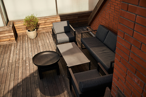 A stylish arrangement of a couch and chairs on a polished wooden floor, creating a warm and inviting atmosphere in a room